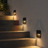 Applique murale LED noire installée dans un escalier