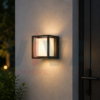 Applique murale extérieure cube noire installée sur un mur extérieur