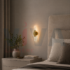 Applique murale dorée avec tube transparent installée dans une chambre moderne