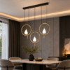 Suspension triple anneaux dorés installée au-dessus d’une table à manger moderne