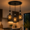 Suspension triple noire grillagée installée dans une cuisine moderne avec lumière chaude