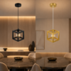 Suspension cube moderne noire et dorée installée au-dessus d’une table