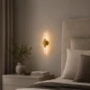 Applique murale dorée avec tube transparent installée dans une chambre moderne