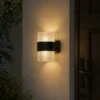 Applique murale extérieure cylindrique noire installée sur un mur extérieur