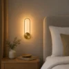 Applique murale LED dorée ovale installée dans une chambre moderne