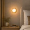 Applique murale ronde dorée installée dans une chambre moderne