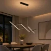 Suspension LED linéaire noire installée au-dessus d’une table à manger moderne