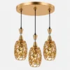 Suspension triple dorée avec trois abat-jours ajourés et design décoratif